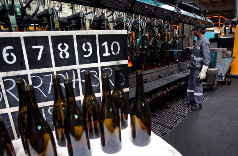 © Reuters. FILE PHOTO: Wine bottle samples stand on a table as a worker checks the production line at a Saverglass' plant in Ras Al Khaimah March 31, 2014. REUTERS/Martin Dokoupil/File Photo