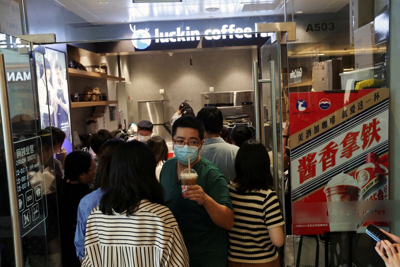 &copy; Reuters. FILE PHOTO: A customer walks out of a Luckin Coffee store next to an advertisement promoting a Kweichow Moutai liquor latte, in Beijing, China, September 4, 2023. REUTERS/Florence Lo/File Photo