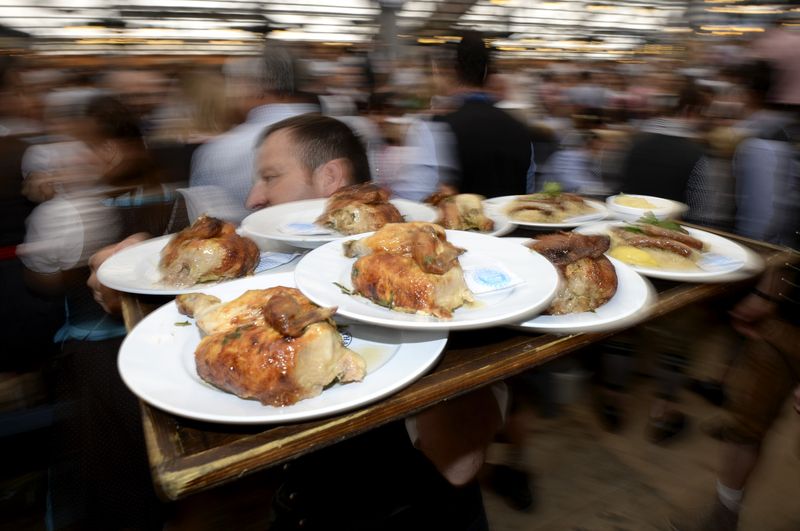&copy; Reuters. FILE PHOTO: A waiter carries a tray of roast chicken during the opening day of the 181st Oktoberfest in Munich September 20, 2014. REUTERS/Lukas Barth/File Photo