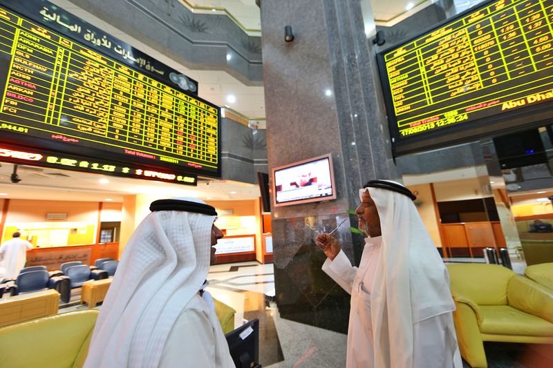 &copy; Reuters. مستثمرون يتابعون حركة تداول الأسهم داخل سوق أبو ظبي للأوراق المالية في صورة من أرشيف رويترز .  