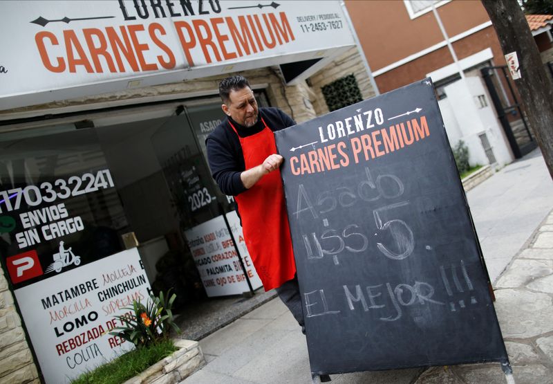 © Reuters. Butcher Marcelo Capobianco, 53, places a sign outside his shop announcing the price of meat at 5 USD at the parallel exchange rate, in Buenos Aires, Argentina September 4, 2023. REUTERS/Agustin Marcarian