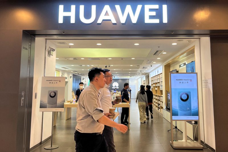 &copy; Reuters. FILE PHOTO: People walk past a Huawei store with advertisements for the Mate 60 series smartphones, at a shopping mall in Beijing, China August 30, 2023. REUTERS/Yelin Mo/File Photo
