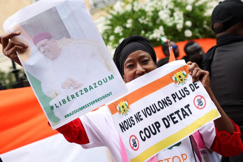 &copy; Reuters. متظاهرة تحمل لافتة أثناء مشاركتها في احتجاج خارج سفارة النيجر في باريس يوم الخامس من أغسطس آب 2023. تصوير: ستيفاني ليكوك - رويترز.