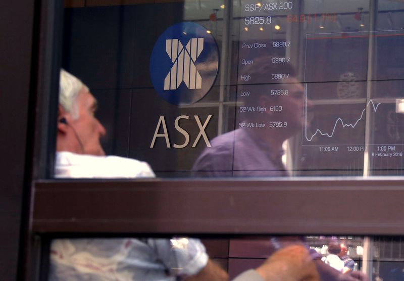 &copy; Reuters. FILE PHOTO: A pedestrian is reflected in a window where an investor sits looking at a board displaying stock prices at the Australian Securities Exchange (ASX) in Sydney, Australia February 9, 2018.   REUTERS/David Gray/File Photo