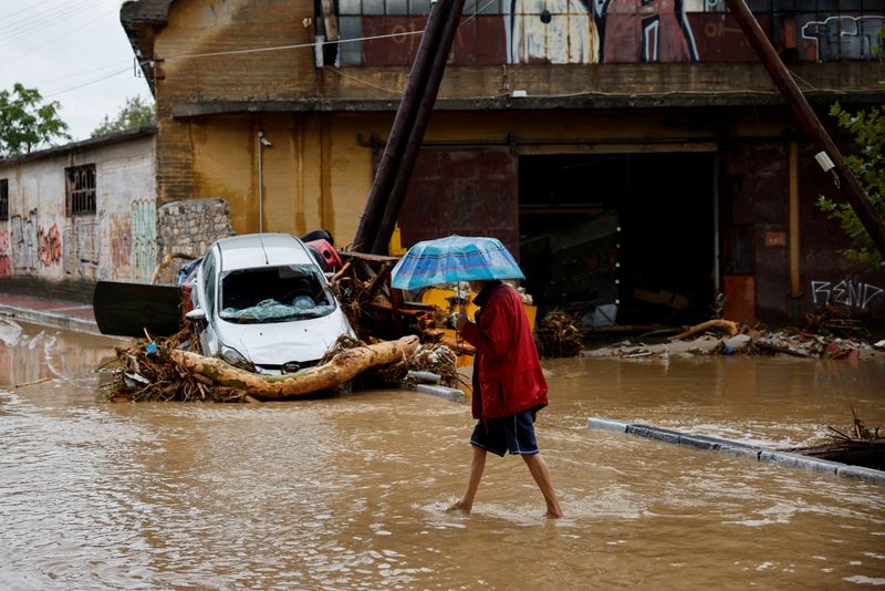 © Reuters. A man holding an umbrella walks on a road flooded due to the impact of storm Daniel, in the city of Volos, Greece, September 6, 2023. REUTERS/Louisa Gouliamaki     