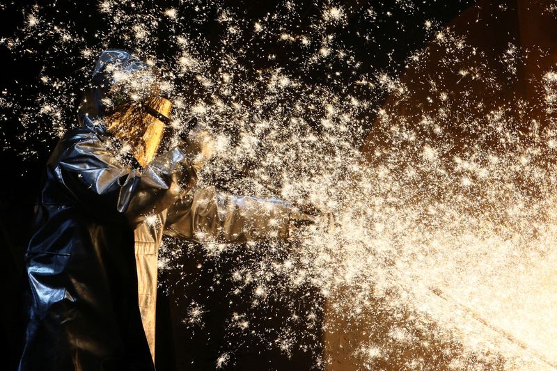 © Reuters. FILE PHOTO: A steel worker of ThyssenKrupp stands amid sparks of raw iron coming from a blast furnace at a ThyssenKrupp steel factory in Duisburg, western Germany, November 14, 2022. REUTERS/Wolfgang Rattay/File Photo