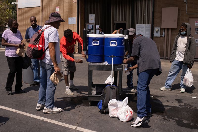 &copy; Reuters. FILE PHOTO: People drink cold water outside the Emergency Aid Coalition during a heat wave in Houston, Texas, U.S., August 25, 2023.  REUTERS/Adrees Latif/File Photo