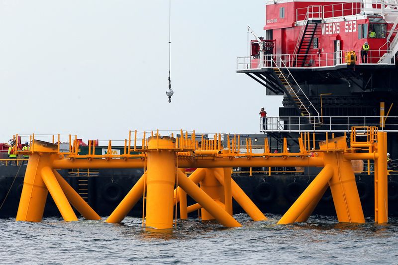 &copy; Reuters. Workers look out from a construction barge next to the first jacket support structure installed to support a turbine for a wind farm in the waters of the Atlantic Ocean off Block Island, Rhode Island July 27, 2015.    REUTERS/Brian Snyder