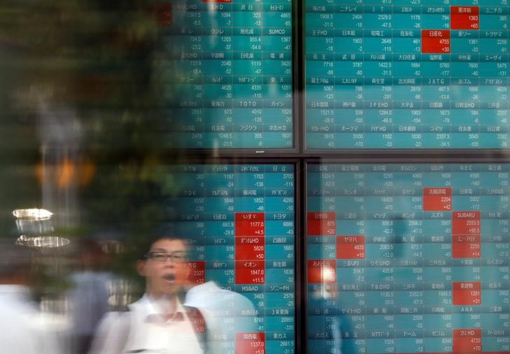 &copy; Reuters. Imagen de archivo de una persona reflejada en una pantalla con información de mercados al exterior de una correduría en Tokio, Japón. 5 agosto 2019. REUTERS/Issei Kato