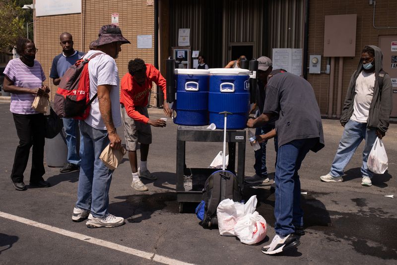 &copy; Reuters. أشخاص يشربون مياها باردة خارج مقر تحالف المساعدات الطارئة خلال موجة حارة تجتاح ولاية تكساس الأمريكية في 25 أغسطس آب 2023 . تصوير : أدريس لطيف - ر