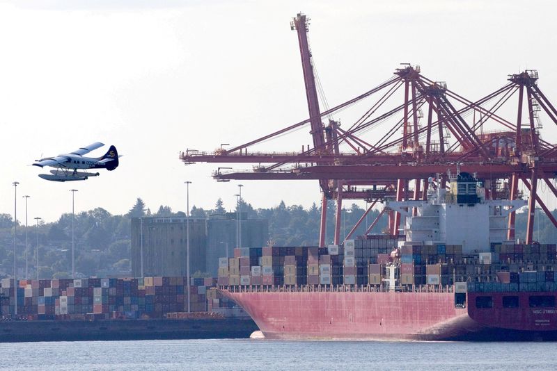 © Reuters. FILE PHOTO: A float plane flies past containers and cranes at the Port of Vancouver, British Columbia, Canada, July 30, 2023. REUTERS/Chris Helgren/File Photo