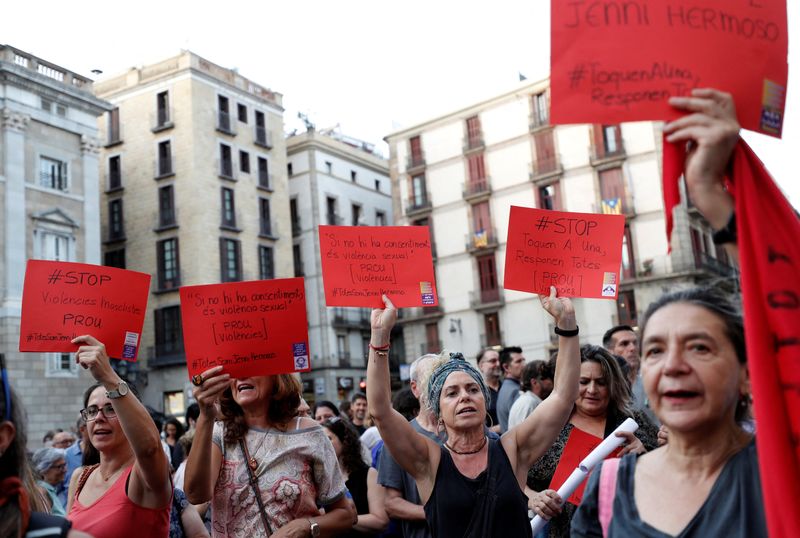 © Reuters. Des femmes tiennent des pancartes représentant des cartons rouges dans le football, sur lesquelles on peut lire 