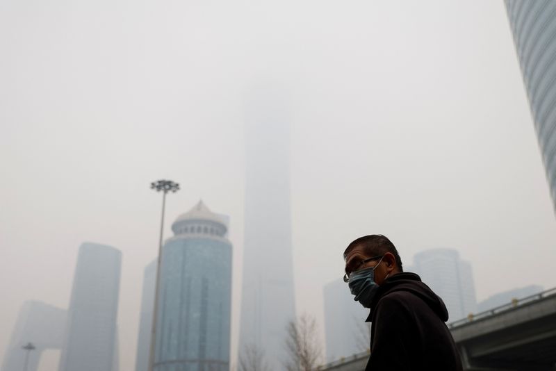 &copy; Reuters. Homem usando máscara caminha na rua durante um dia com ar poluído em Pequim, China
13/02/2021
REUTERS/Carlos Garcia Rawlins