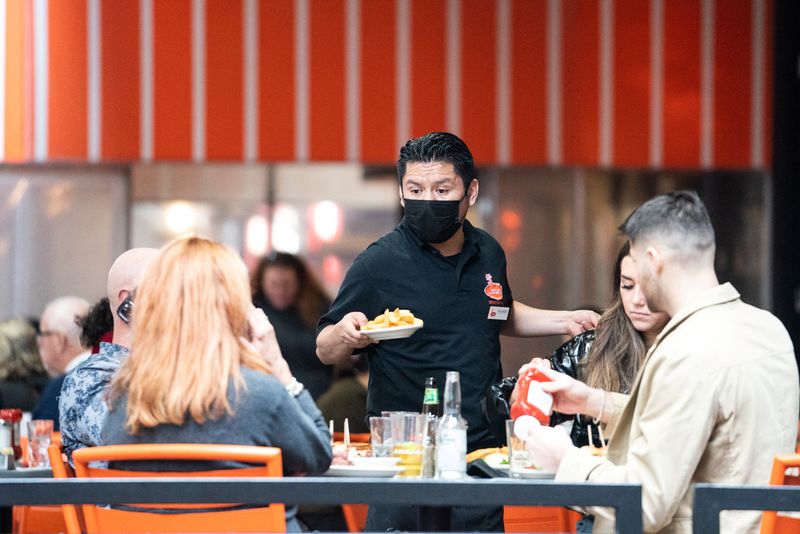 &copy; Reuters. FOTO DE ARCHIVO. Un mesero sirve comida en un restaurante cerca de Times Squareen la Ciudad de Nueva York, EEUU, Diciembre 16, 2021. REUTERS/Jeenah Moon