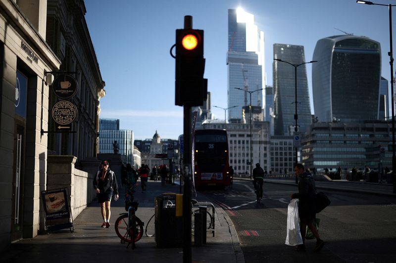 &copy; Reuters. FILE PHOTO: People walk across the London Bridge during the morning rush hour, with the City of London's financial district in the background, in London, Britain, April 13, 2023. REUTERS/Henry Nicholls/File Photo