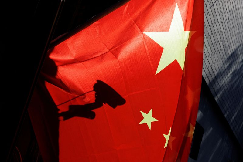 &copy; Reuters. FILE PHOTO: FILE PHOTO: A surveillance camera is silhouetted behind a Chinese national flag in Beijing, China, November 3, 2022. REUTERS/Thomas Peter/File Photo