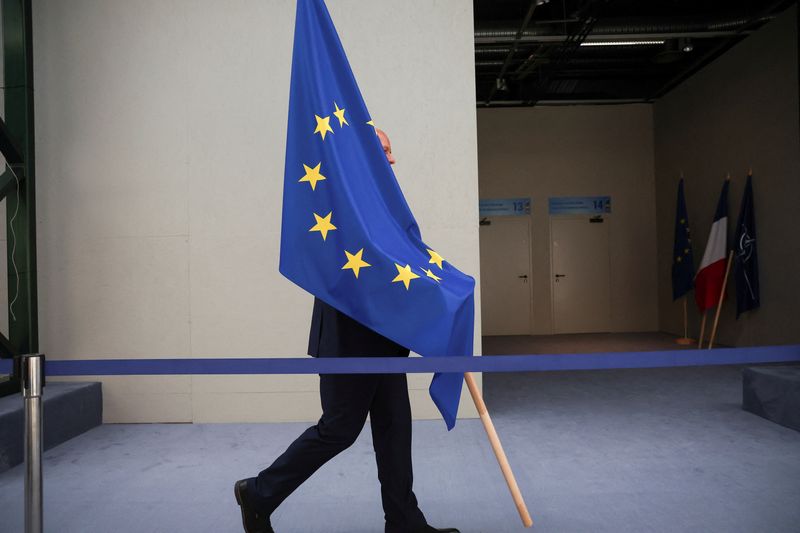 &copy; Reuters. Une personne porte le drapeau de l'UE lors d'un sommet des dirigeants de l'OTAN à Vilnius. /Photo prise le 12 juillet/REUTERS/Kacper Pempel