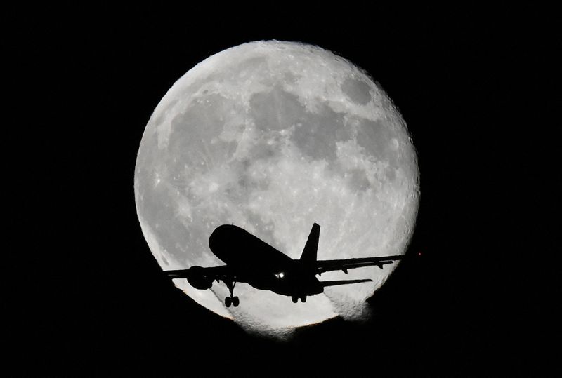 &copy; Reuters. FILE PHOTO: An aircraft passes in front of the moon as it makes its landing approach to Heathrow Airport in London, Britain, November 9, 2022. REUTERS/Toby Melville/File Photo    