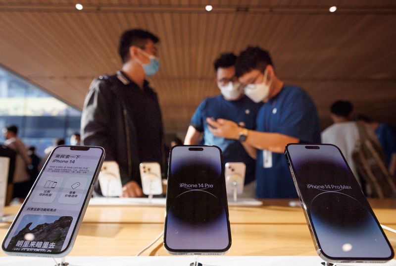 &copy; Reuters. Un cliente parla con gli addetti alle vendite in un Apple Store durante la vendita dei nuovi modelli di iPhone 14 di Apple a Pechino, Cina, 16 settembre 2022. REUTERS/Thomas Peter/File Photo