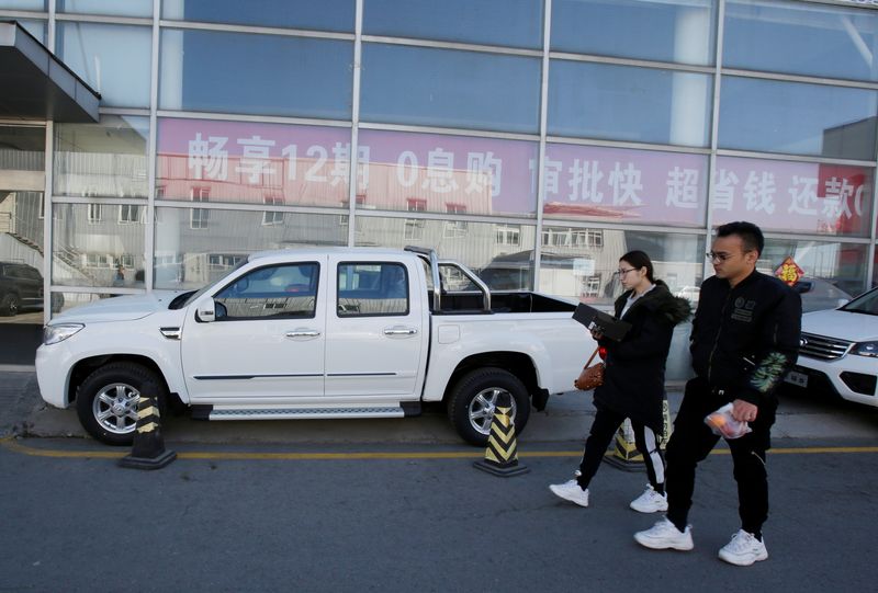 &copy; Reuters. Des personnes devant un concessionnaire automobile à Pékin, en Chine. /Photo prise le 21 mars 2019/REUTERS/Jason Lee