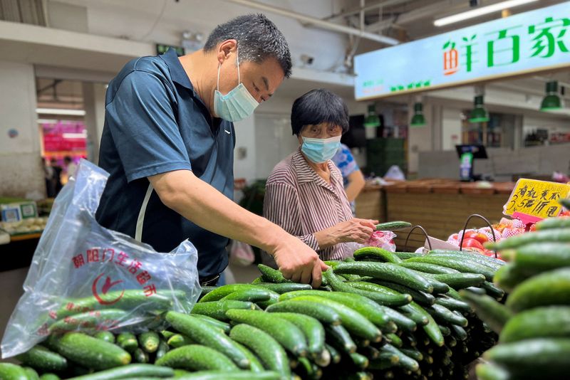 &copy; Reuters. Photo d'archives des clients qui achètent des légumes dans un marché à Pékin. /Photo prise le 10 août 2023 à Pékin, Chine/REUTERS/Yew Lun Tian
