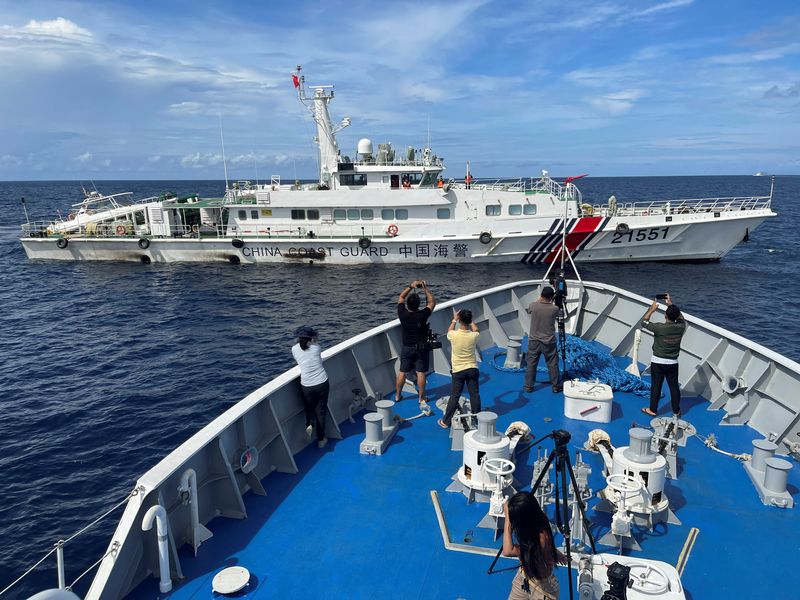 &copy; Reuters. Journalists onboard a Philippines Coast Guard ship take photos of a China Coast Guard vessel, during a resupply mission for troops stationed at a grounded Philippines ship, in the South China Sea, September 8, 2023. REUTERS/Jay Ereno NO RESALES. NO ARCHIV