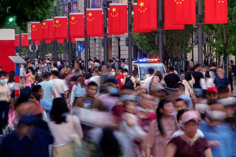 &copy; Reuters. FILE PHOTO: People walk along Nanjing Pedestrian Road, a main shopping area, following the outbreak of the coronavirus disease (COVID-19), in Shanghai, China May 10, 2021. REUTERS/Aly Song/File Photo