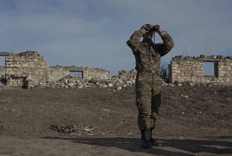 &copy; Reuters. جندي أرمني ينظر من خلال منظار وهو يقف في مواقع قتالية في منطقة كاراباخ في صورة من أرشيف رويترز.
