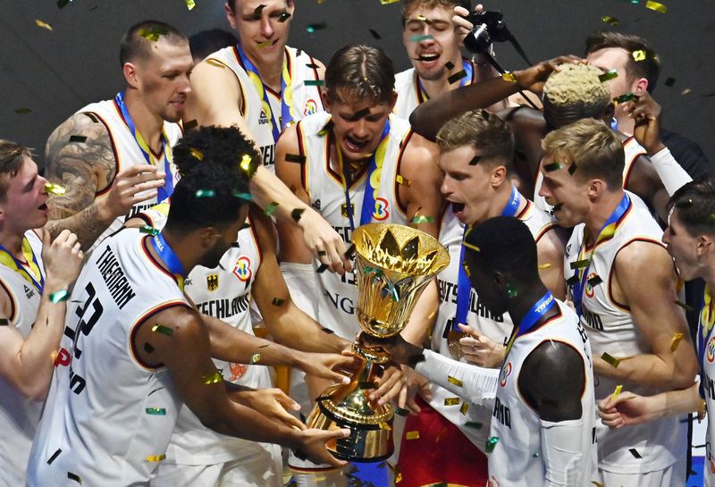 © Reuters. Basketball - FIBA World Cup 2023 - Final - Germany v Serbia - Mall of Asia Arena, Manila, Philippines - September 10, 2023 Germany players celebrate with the trophy after winning the FIBA World Cup 2023 Final REUTERS/Lisa Marie David