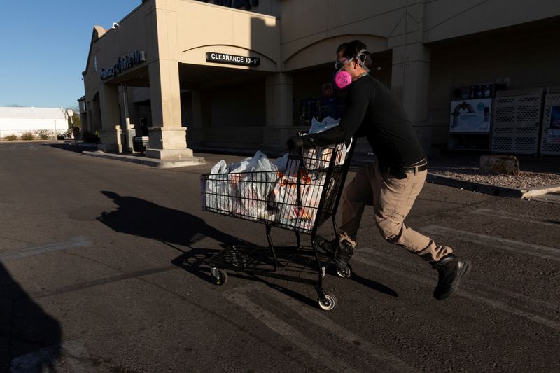 © Reuters. FILE PHOTO: Instacart employee Eric Cohn, 34, heads to his car outside a Safeway grocery store while wearing a respirator mask to help protect himself and slow the spread of the coronavirus disease (COVID-19) in Tucson, Arizona, U.S., April 4, 2020. Picture taken April 4, 2020.  REUTERS/Cheney Orr