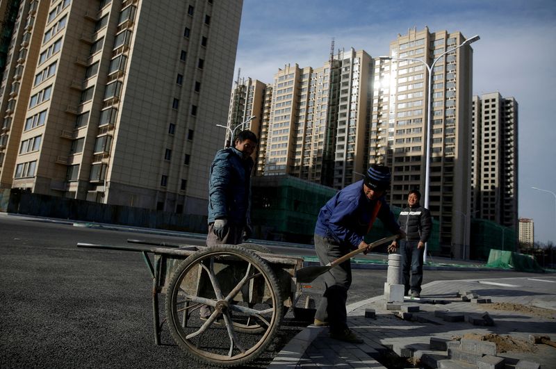 © Reuters. FILE PHOTO: Men work near residential apartment blocks under construction on the outskirts of Beijing, China November 29, 2017. REUTERS/Thomas Peter/File Photo