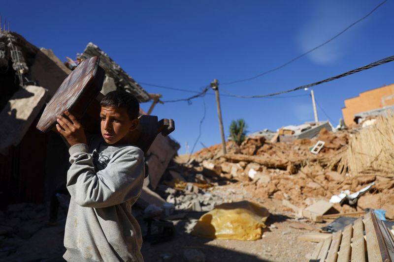 © Reuters. A person carries an item of furniture, in the aftermath of a deadly earthquake, in a hamlet on the outskirts of Talaat N'Yaaqoub, Morocco, September 11, 2023. REUTERS/Hannah McKay