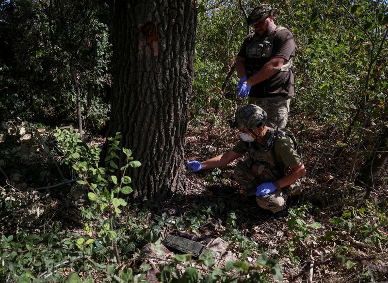 © Reuters. FILE PHOTO: Ukrainian servicemen check the body of a dead Russian soldier, amid Russia's attack on Ukraine, in the village of Blahodatne in Donetsk Region Ukraine September 8, 2023. REUTERS/Oleksandr Ratushniak/File Photo