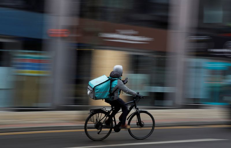 &copy; Reuters. FILE PHOTO: A deliveroo delivery driver cycles through the centre of Manchester, Britain, March 8, 2021. REUTERS/Phil Noble/File Photo