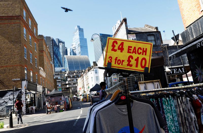 © Reuters. FILE PHOTO: A view of City of London financial district behind Petticoat Lane street market, where discounted clothing is on sale, in London, Britain, August 23 2023.  REUTERS/Peter Nicholls/File Photo