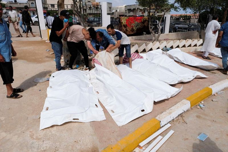 &copy; Reuters. أشخاص ينظرون إلى جثث خارج المستشفى بعد عاصفة قوية وأمطار غزيرة مدينة درنة في ليبيا يوم الثلاثاء. تصوير: عصام عمران الفيتوري -رويترز.