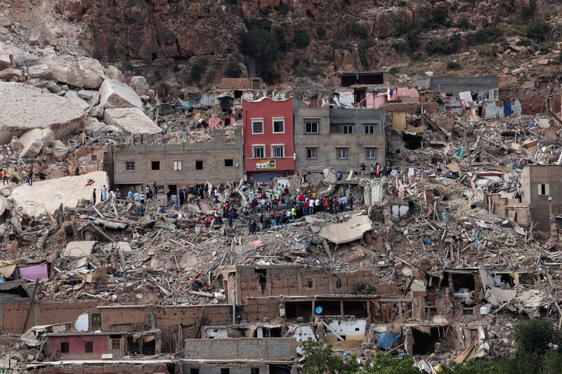 &copy; Reuters. أشخاص يقفون على الأنقاض في قرية إيمي إن تالا التي دمرها الزلزال في المغرب يوم الثلاثاء. تصوير: تصوير: إميلي ماضي - رويترز.