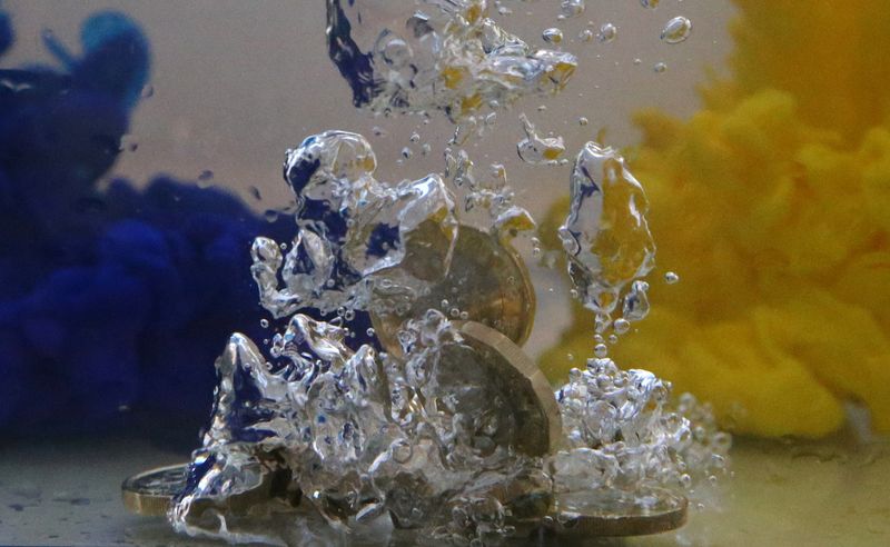 &copy; Reuters. FILE PHOTO: UK pound coins plunge into water coloured with the European Union flag colours in this illustration picture, October 26, 2017. REUTERS/Dado Ruvic/File Photo