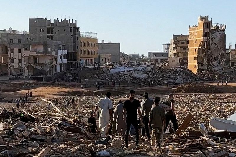 &copy; Reuters. People walk through debris after a powerful storm and heavy rainfall hit Libya, in Derna, Libya, September 12, 2023 in this still image from video obtained from social media. ALI M. BOMHADI/via REUTERS