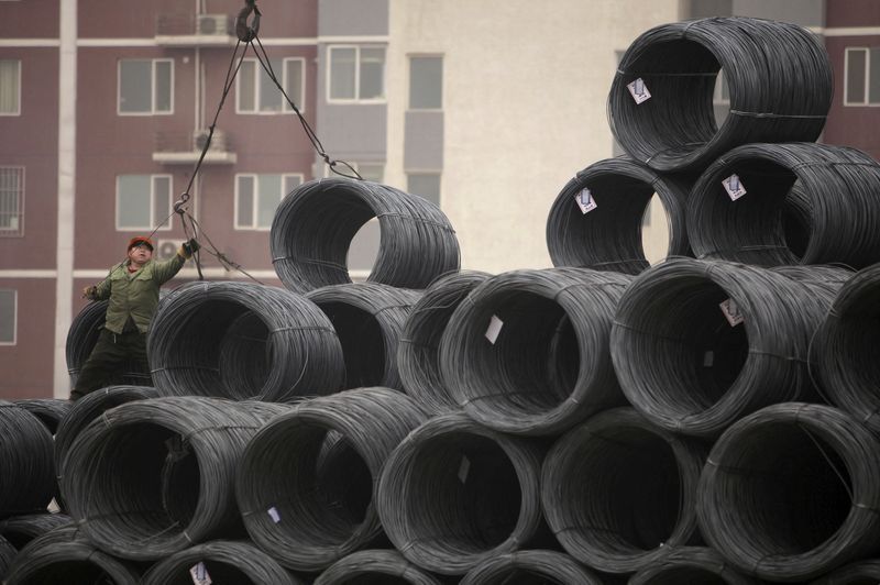 &copy; Reuters. FOTO DE ARCHIVO: Un obrero trabaja con bobinas de alambre de acero en un mercado mayorista de acero en Pekín. 17 de enero de 2012.   REUTERS/Soo Hoo Zheyang