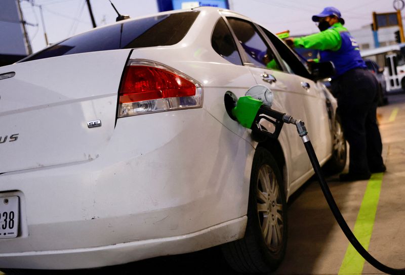 &copy; Reuters. Un benzinaio rifornisce un'auto di un residente del Texas in una stazione di servizio a Ciudad Juarez, in Messico, il 14 marzo 2022. REUTERS/Jose Luis Gonzalez/Foto d'archivio