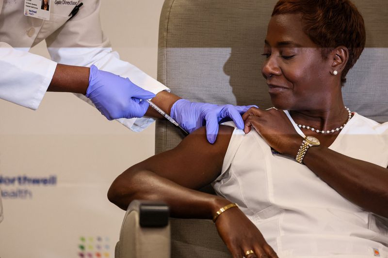 © Reuters. Sandra Lindsay, a nurse at Long Island Jewish Medical Center who was the first American to receive the initial COVID vaccine, is inoculated with the updated coronavirus disease (COVID-19) vaccine by Dr. Michelle Chester from Northwell Health at Long Island Jewish Medical Center in New Hyde Park, New York, U.S., September 13, 2023.  REUTERS/Brendan McDermid