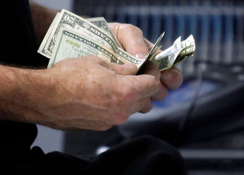 &copy; Reuters. FILE PHOTO: A customer counts his cash at the register while purchasing an item at a Best Buy store in Flushing, New York March 27, 2010.   REUTERS/Jessica Rinaldi/File Photo