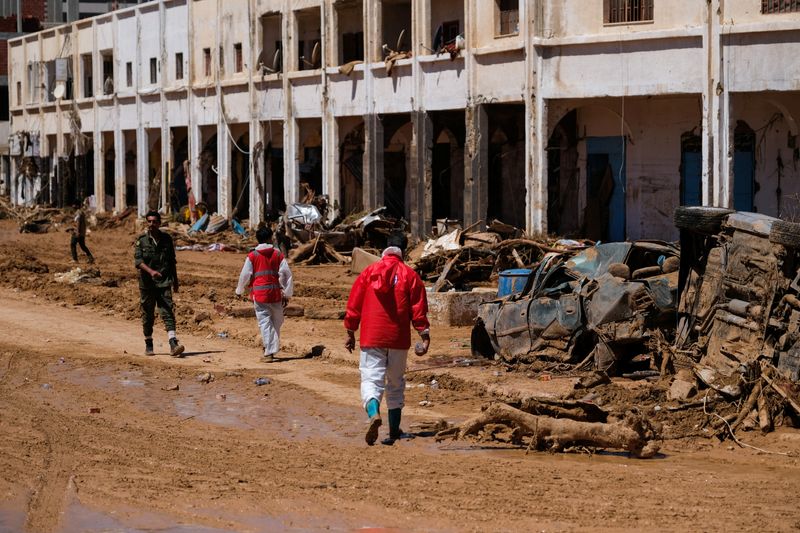 &copy; Reuters. Des membres du Croissant Rouge marchent parmi des décombres liées aux inondations à Derna en Libye. /Photo prise le 13 septembre 2023/REUTERS/Esam Omran Al-Fetori