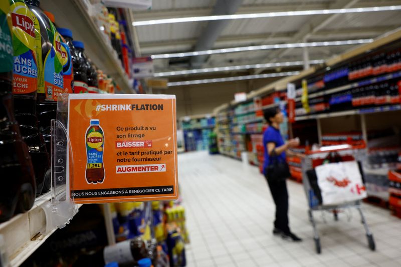 &copy; Reuters. A sign reading "Shrinkflation, This product has seen its liter decrease and the price charged by our supplier increase" as a customer shops at a Carrefour supermarket in Montesson near Paris, France, September 13, 2023. REUTERS/Sarah Meyssonnier  