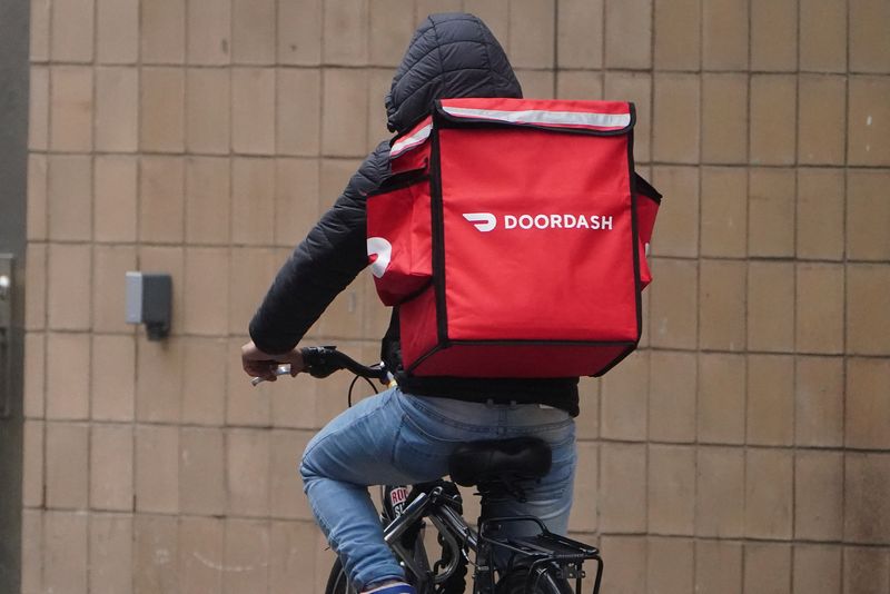 &copy; Reuters. A delivery person for Doordash rides his bike in the rain during the coronavirus disease (COVID-19) pandemic in the Manhattan borough of New York City, New York, U.S., November 13, 2020. REUTERS/Carlo Allegri/File Photo