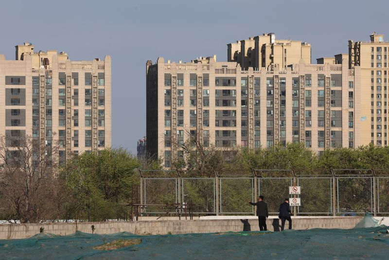 &copy; Reuters. FOTO DE ARCHIVO. Hombres parados cerca de edificios residenciales en Pekín, China, 14 de abril de 2022. REUTERS/Tingshu Wang