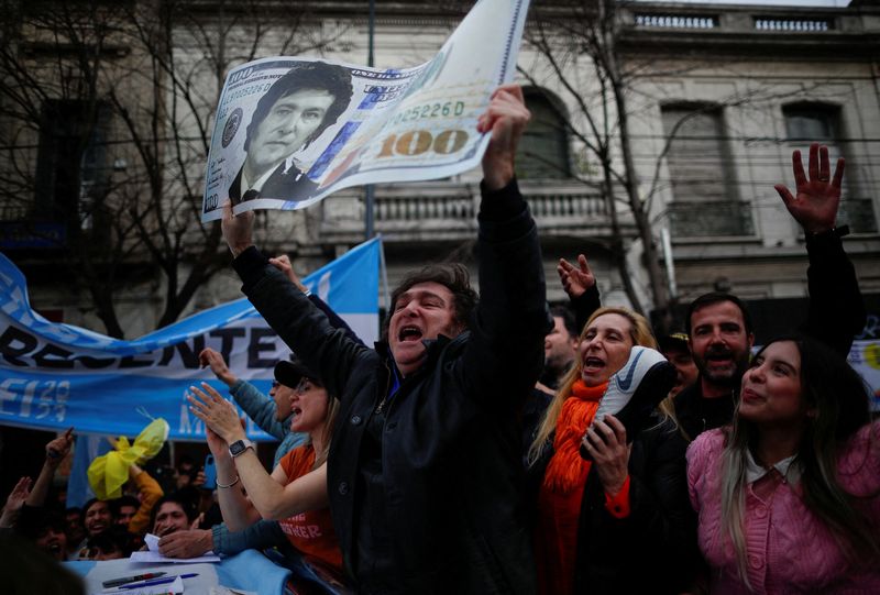 &copy; Reuters. FILE PHOTO: Argentine presidential candidate Javier Milei for La Libertad Avanza coalition holds a placard depicting a dollar bill with his face, during a campaign rally in La Plata, Buenos Aires, Argentina, September 12, 2023. REUTERS/Agustin Marcarian/F