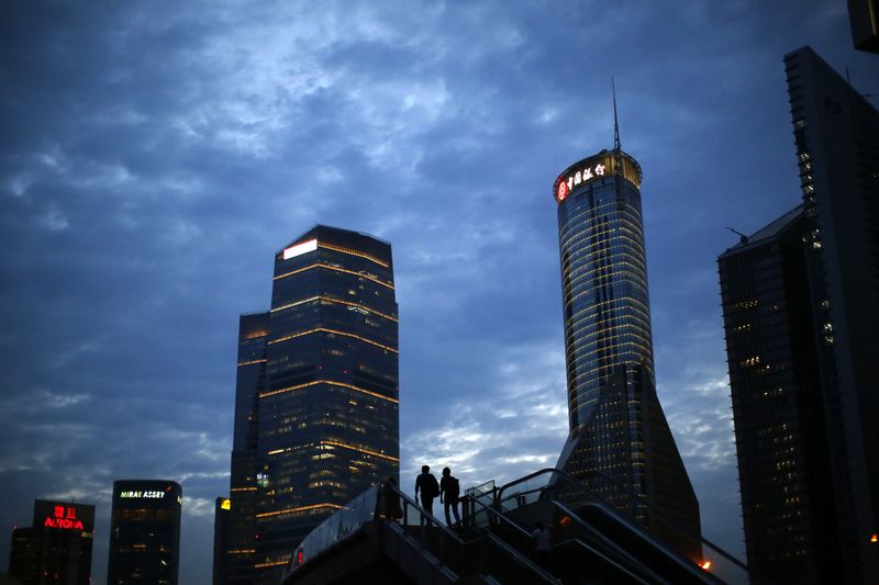 &copy; Reuters. FILE PHOTO: Men walk on a bridge at Pudong financial district in Shanghai August 11, 2014. REUTERS/Carlos Barria/File Photo  