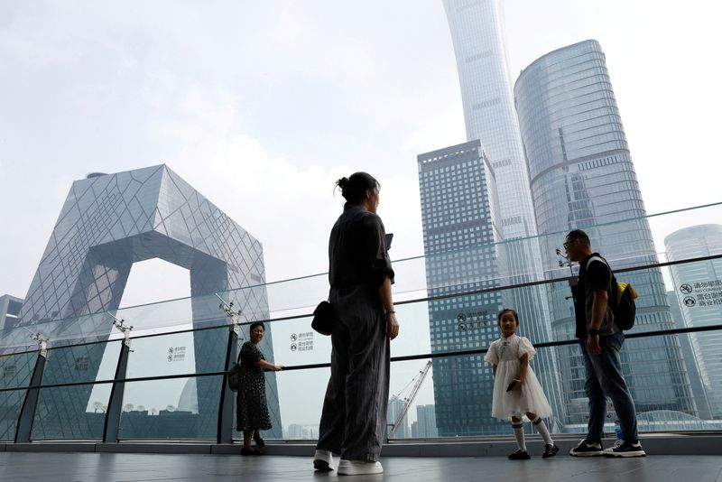 &copy; Reuters. FILE PHOTO: People stand at a shopping mall near the CCTV headquarters and China Zun skyscraper, in Beijing's central business district (CBD), China September 7, 2023. REUTERS/Tingshu Wang/File Photo
